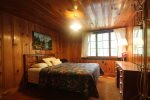 Master bedroom has a queen bed with a window viewing the beautiful woods nearby.